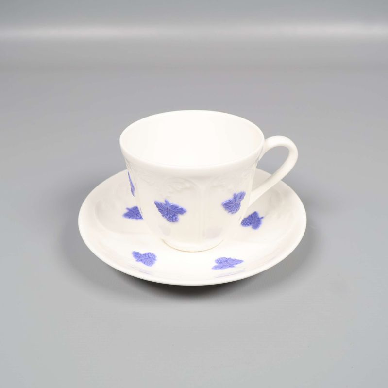 Vit kaffekopp med blå blommor på matchande fat