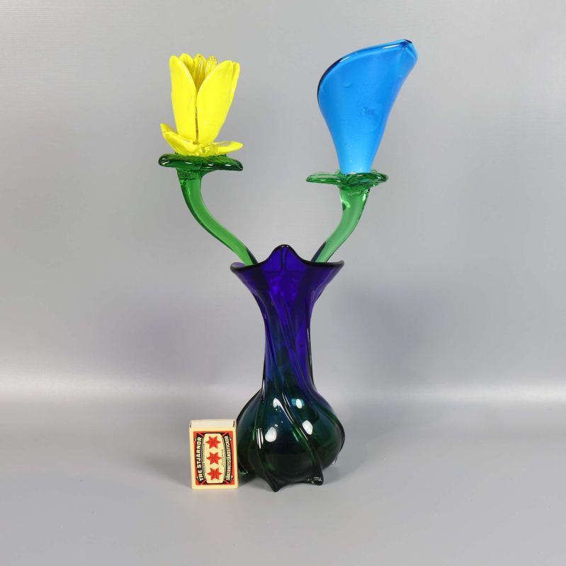 Glasvas med blommor bredvid tändsticksask för storleksjämförelse