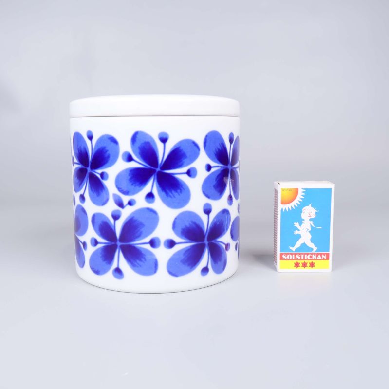 Burk i blått Mon Amie-mönster bredvid tändsticksask