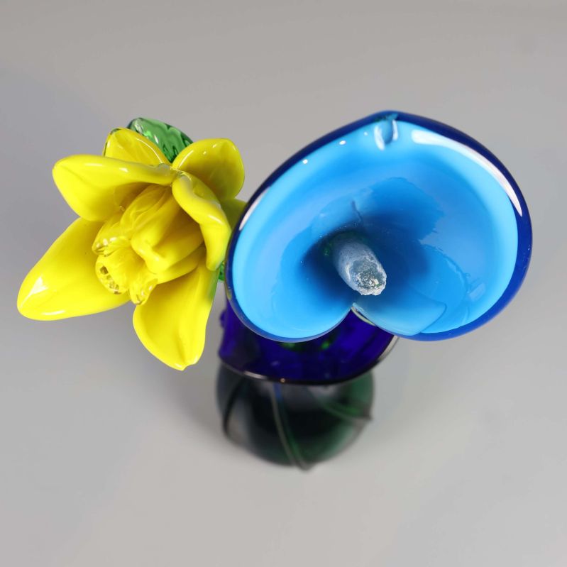 Toppvy på glasvas med två färgade blommor