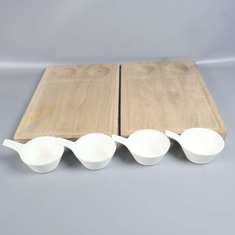 Närbild på två plankor och fyra vita skålar