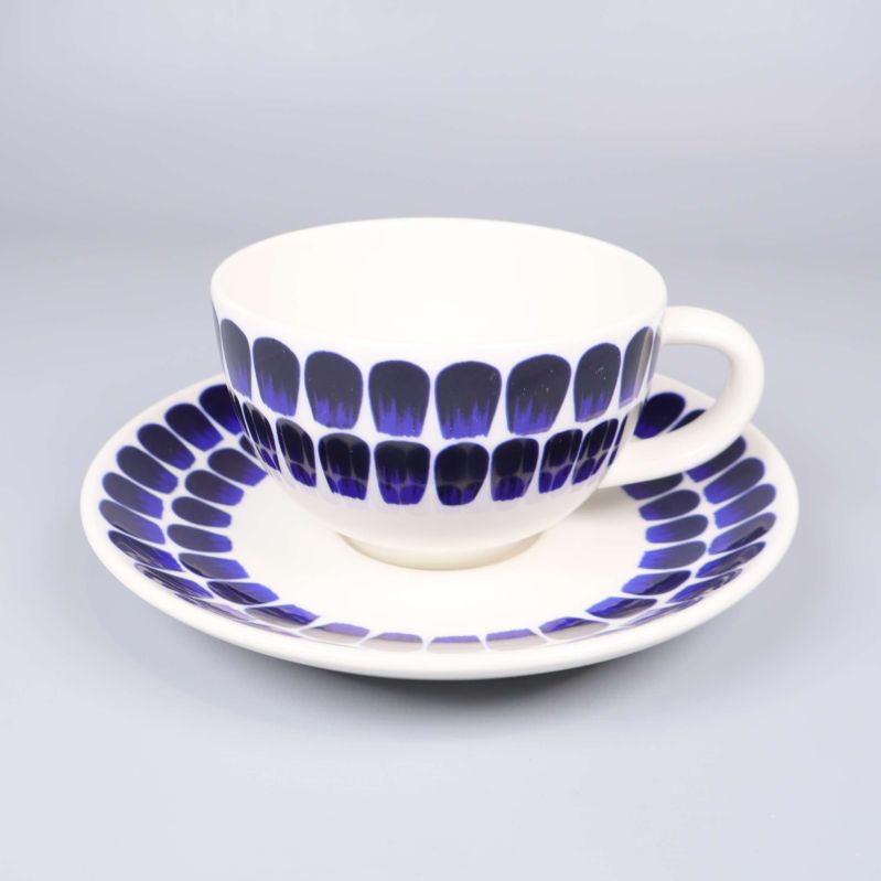 Närbild på en kaffekopp med fat, mönstrad dekor