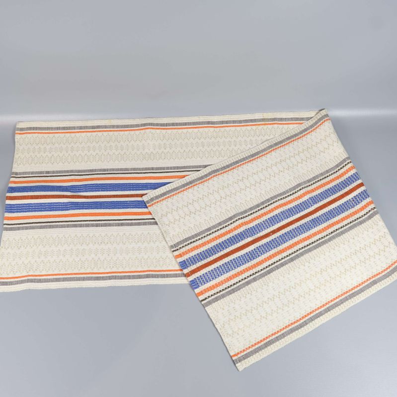 Löpare i vitt med färgglada ränder utlagd på bord