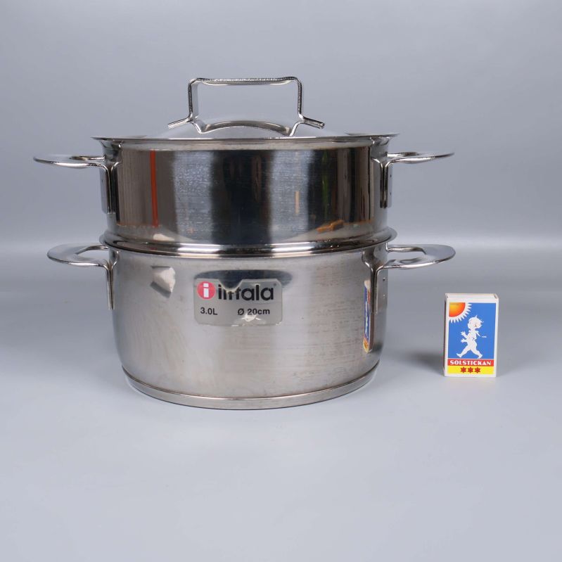 Ångkokare i stål bredvid tändsticksask för storleksjämförelse