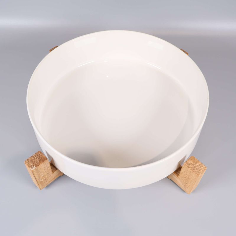 Vit serveringsskål med träställning, fotad ovanifrån