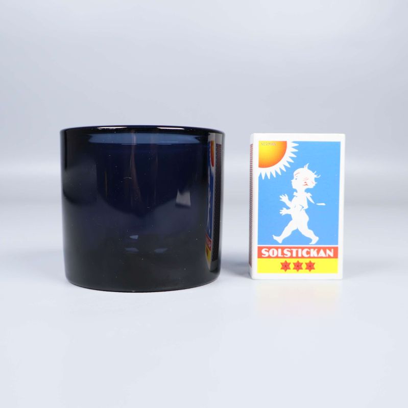 Blå glaslykta bredvid en tändsticksask för storleksjämförelse