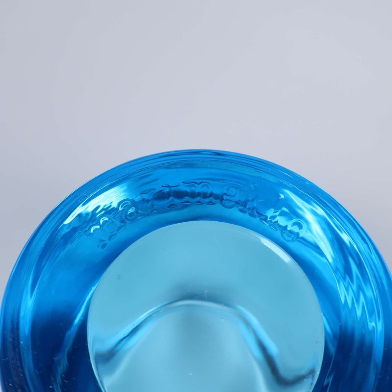 Närbild av präglad text på ljuslyktans kant