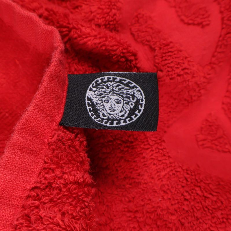 Svart tygmärke med Medusa-symbolen på röd handduk