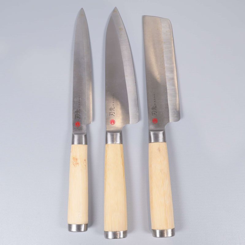 Tre köksknivar med ljusa trähandtag och olika blad