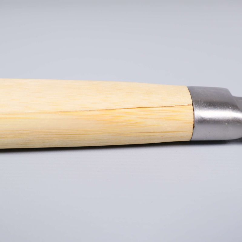 Närbild på ljus trähandtag till kökskniv med tydlig spricka