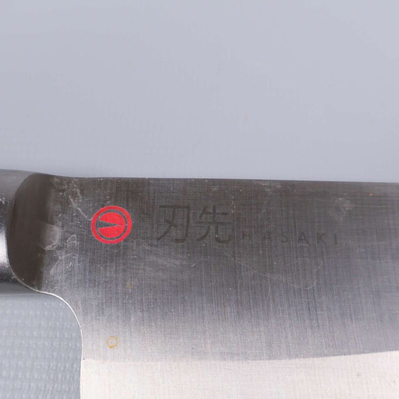 Hasaki-logotyp med japansk text ingraverad på knivblad