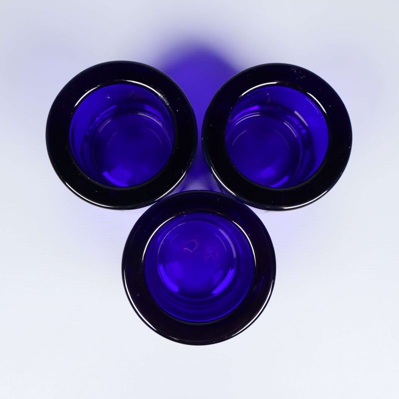 Tre blå ljuslyktor sedda ovanifrån mot vit bakgrund