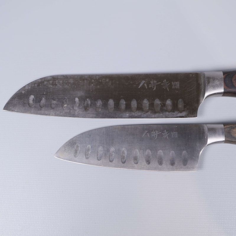 Närbild på knivblad med japansk gravyr och urgröpning