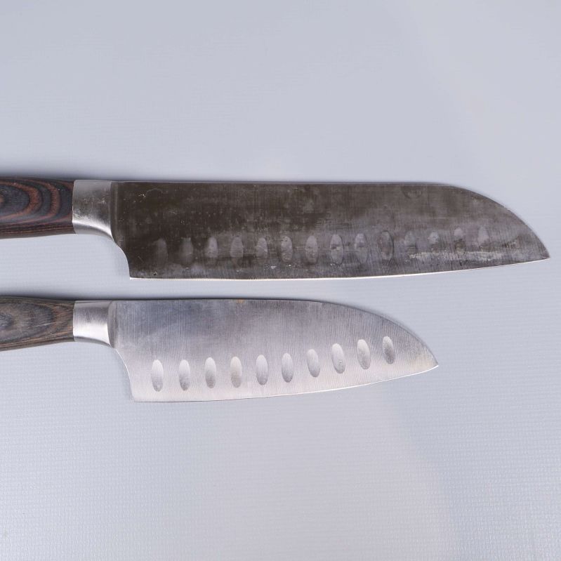 Två knivblad med urgröpningar och japansk gravyr syns ovanifrån