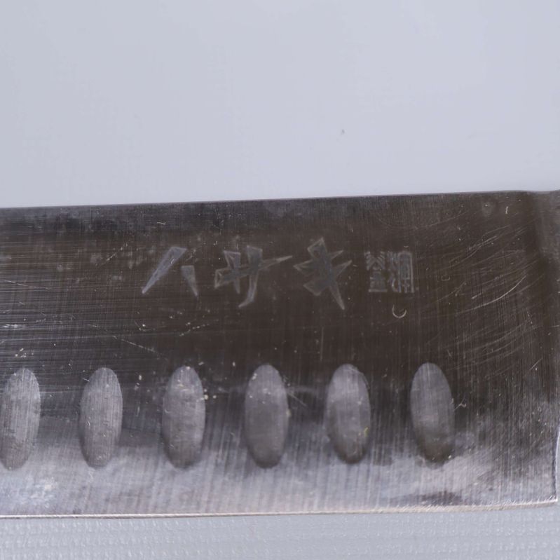 Närbild på japansk gravyr på ett av knivbladen