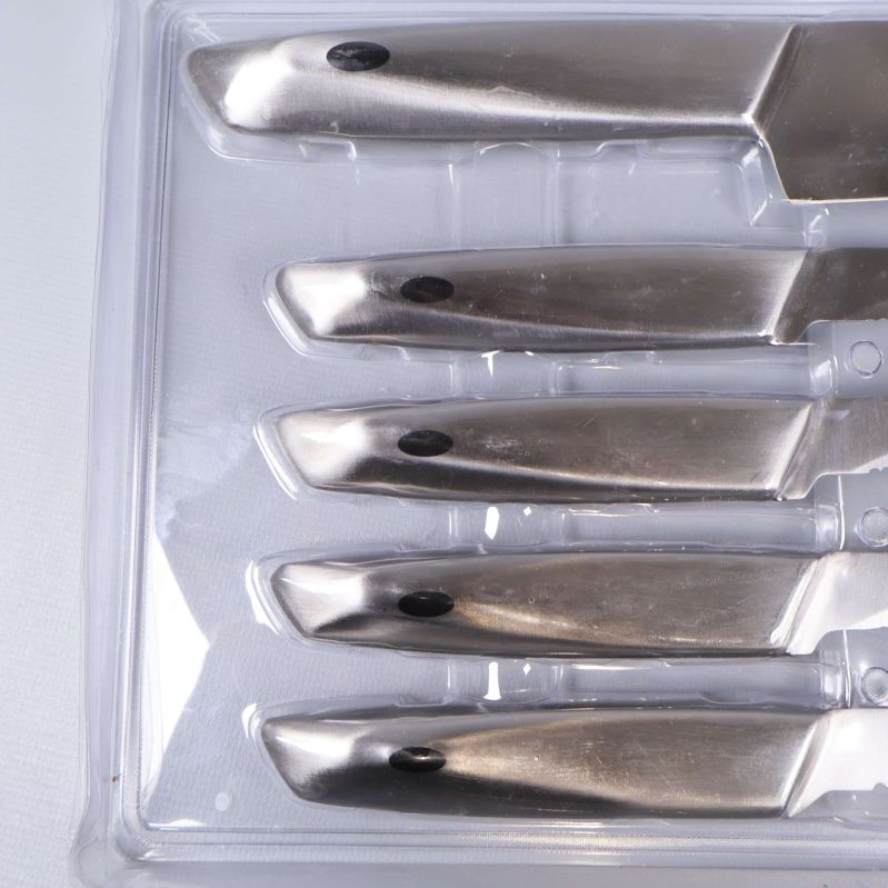 Handtag av köttknivar i silverfärg, liggande i fodral