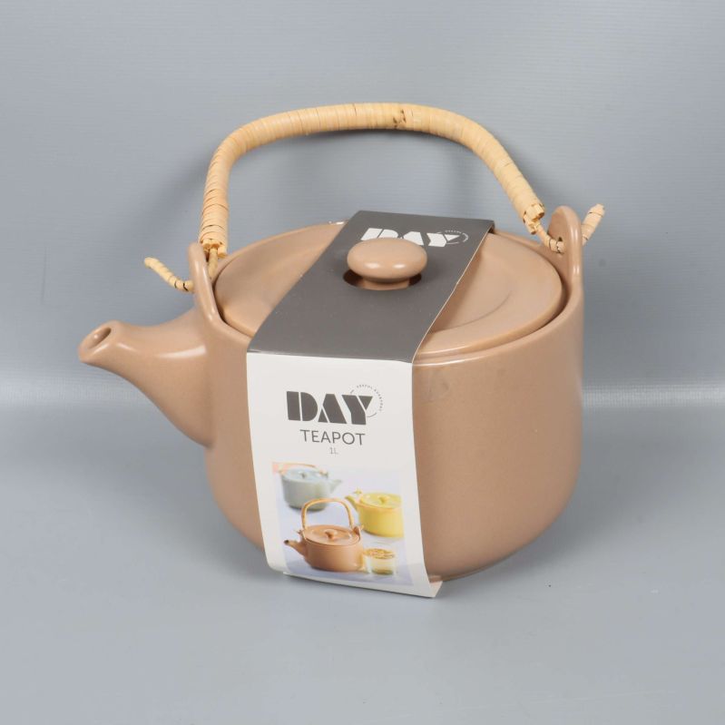 Beige tekanna med bambuhandtag och etikett