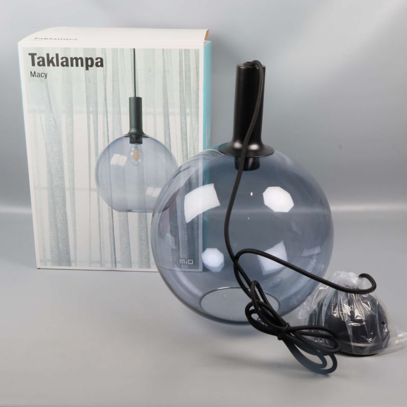 Taklampa med globformad skärm framför kartong