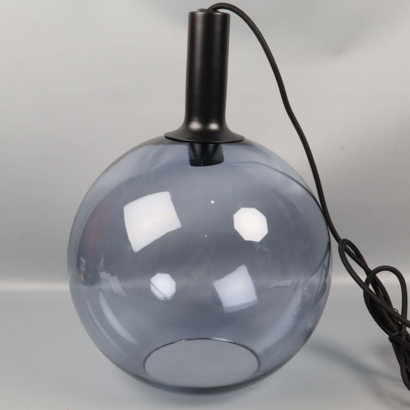 Närbild på taklampa med svart upphängning