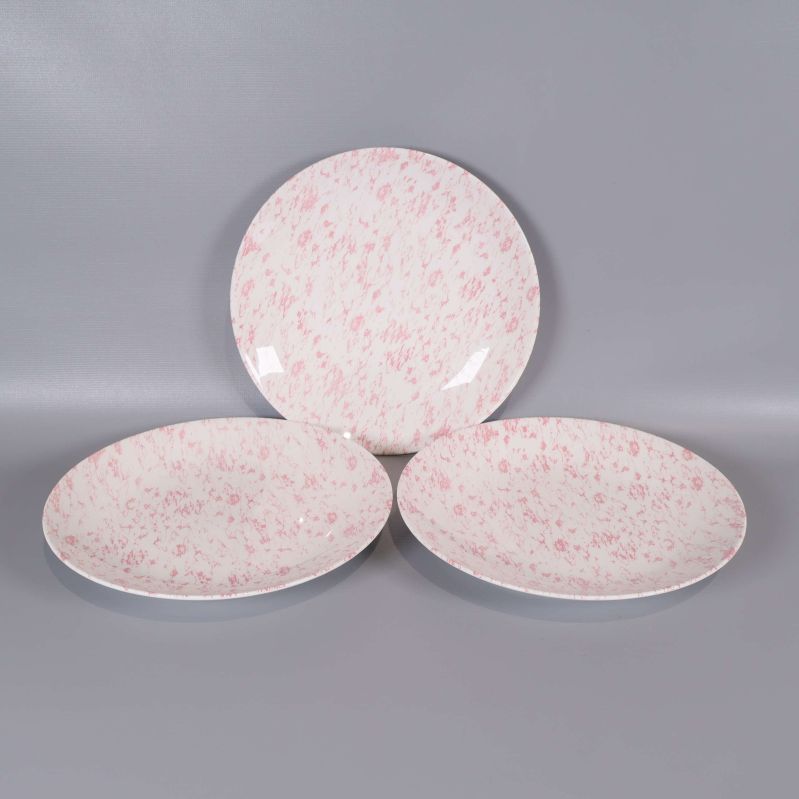 Tre assietter i rosa och vitt porslin, utplacerade på rad