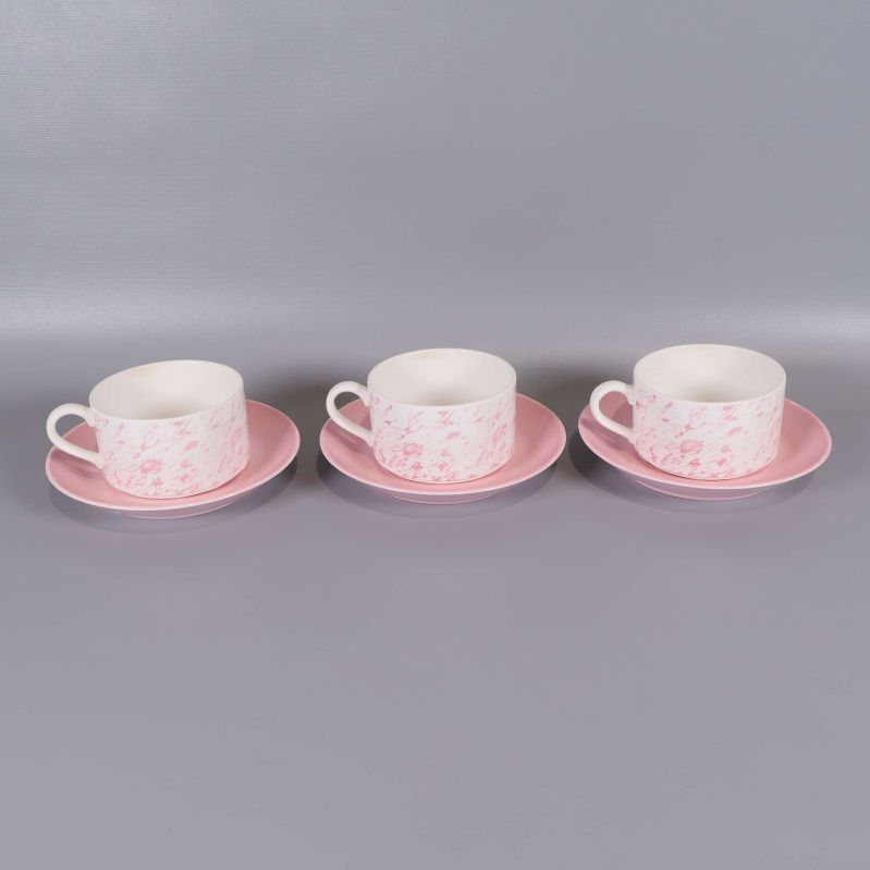 Tre kaffekoppar med rosa fat placerade i rad