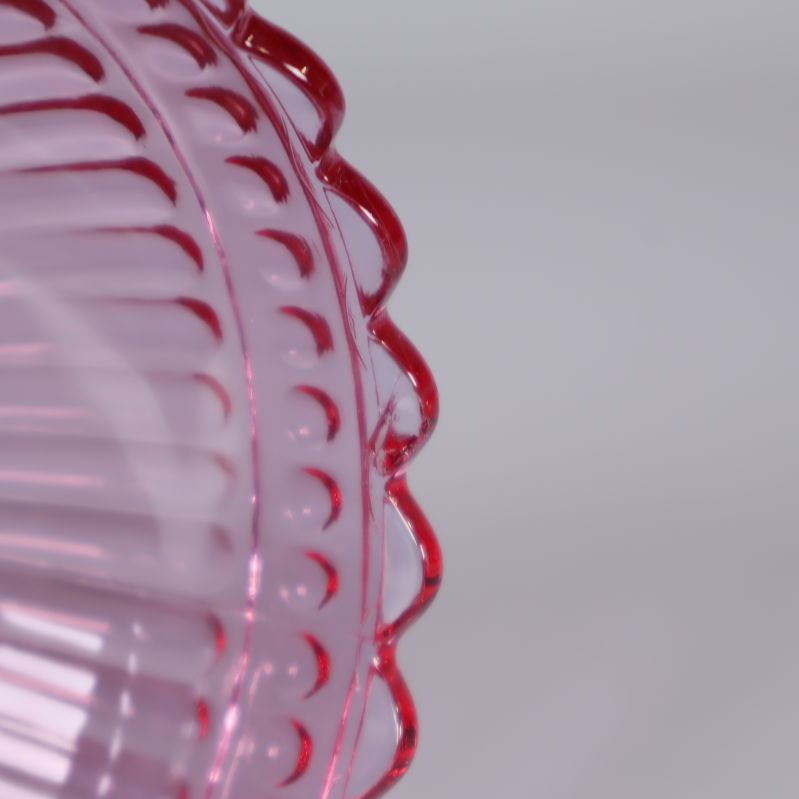 Närbild på rosa räfflade sidan av glasskål