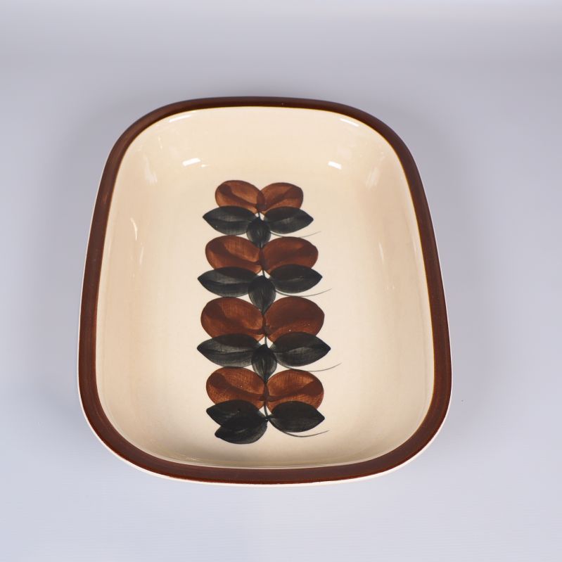 Rektangulär form med bladmönster i svart och brunt, smalare riktning