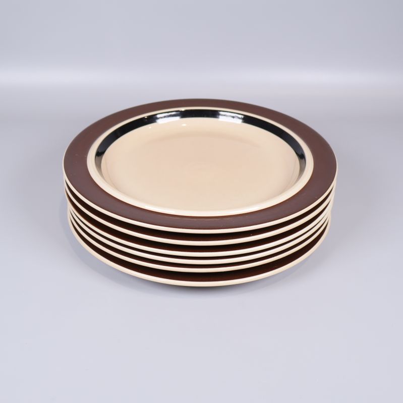 Staplade tallrikar med bred brun kant och beige mitt
