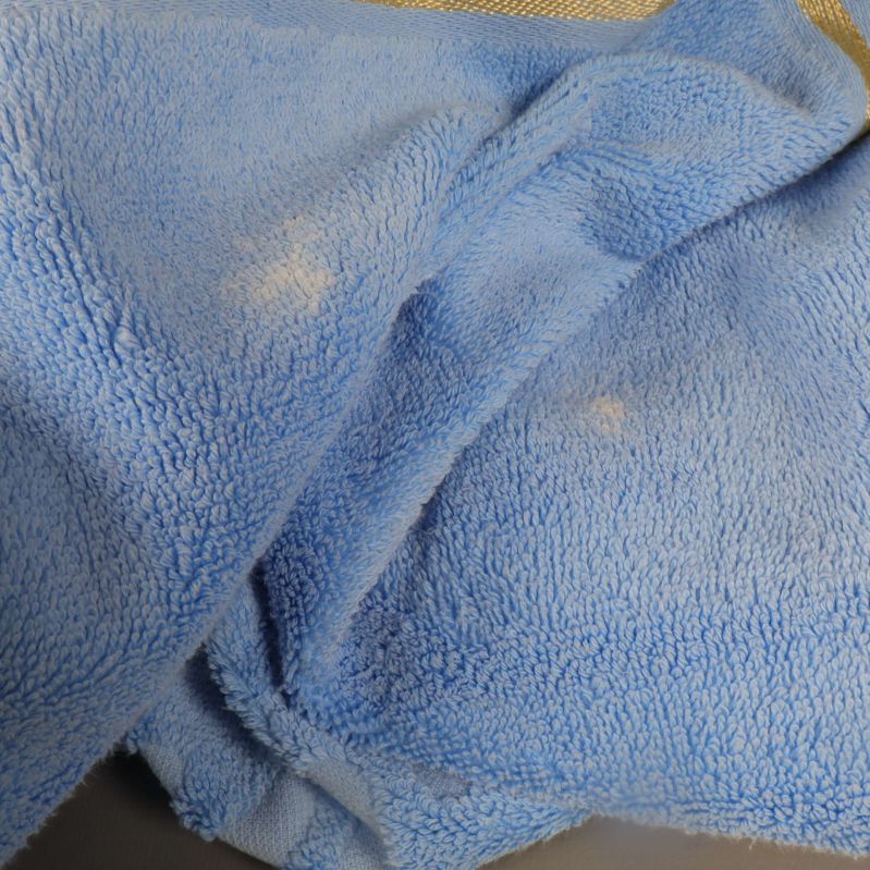 Närbild på luddig struktur med ljusa fläckar på handduk