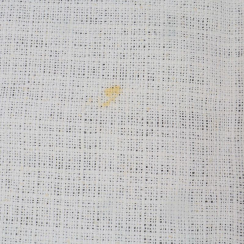 Detaljbild på liten fläck på vit duk