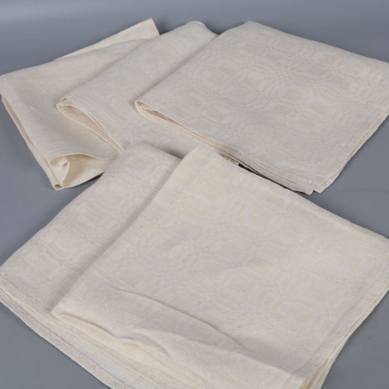 Fem vikta servetter i ljus färg visas ovanpå varandra