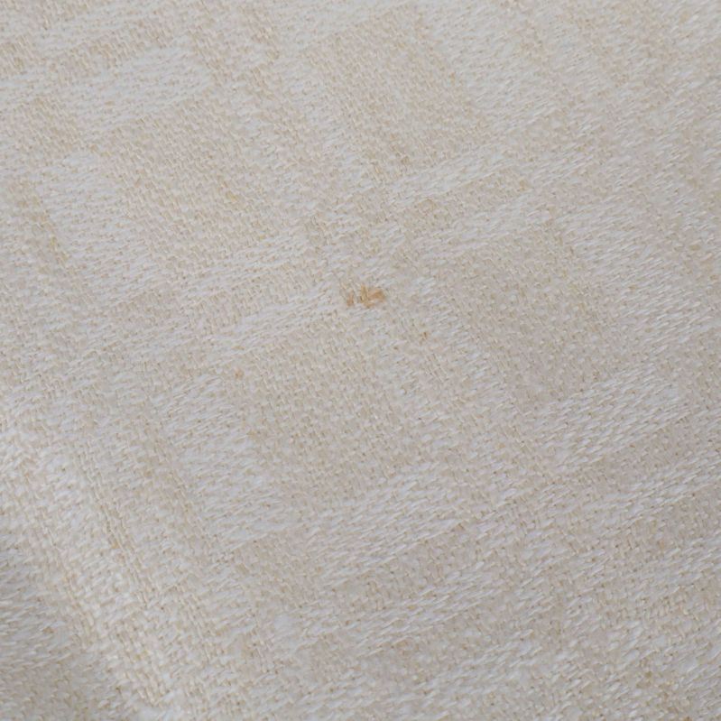 Detaljbild på liten fläck på vit duk