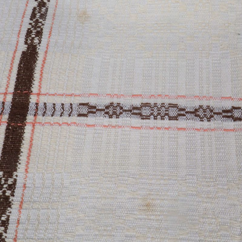 Närbild på rutmönster med brun dekorrand och fläckar