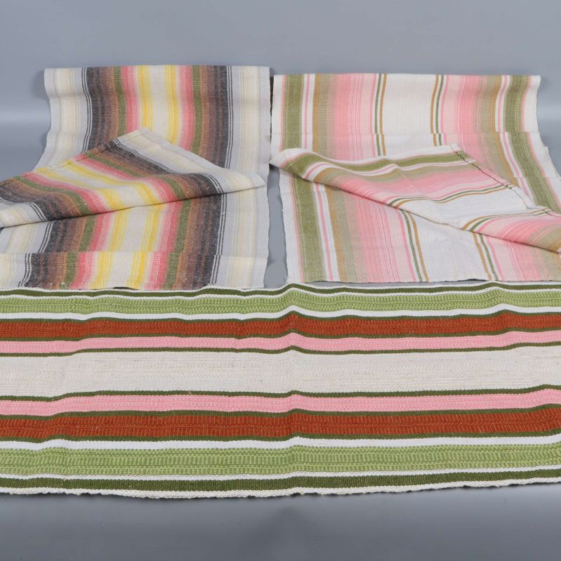 Tre randiga löpare i olika färger bredvid varandra