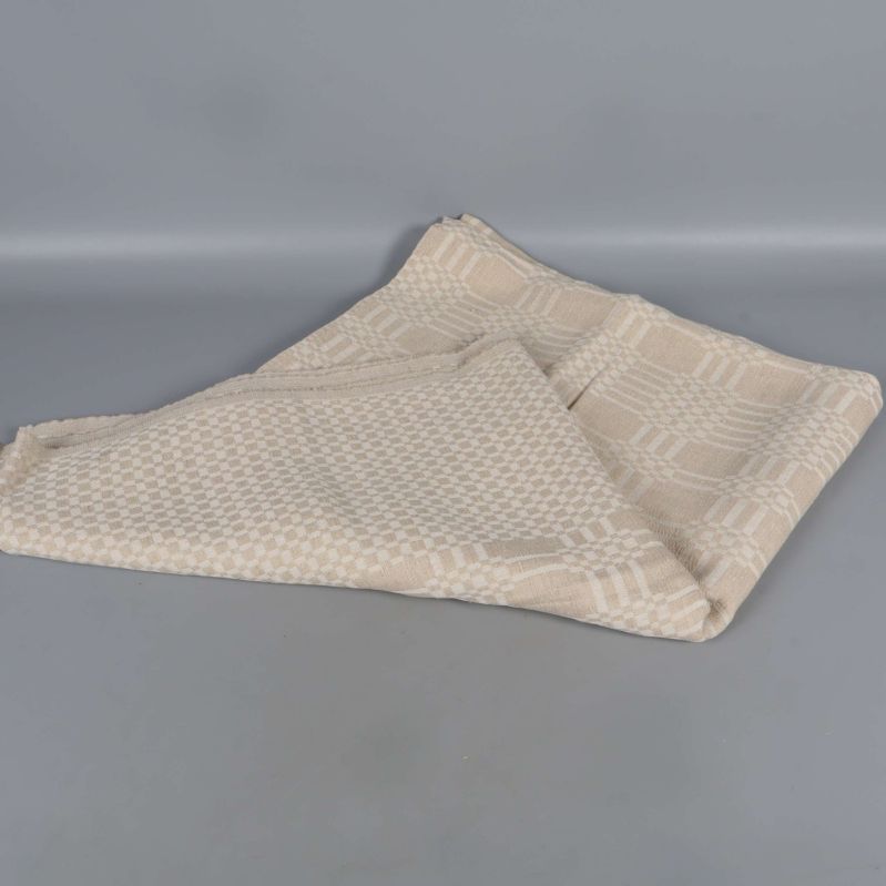 Beige duk i rutigt mönster delvis vikt i hörnet