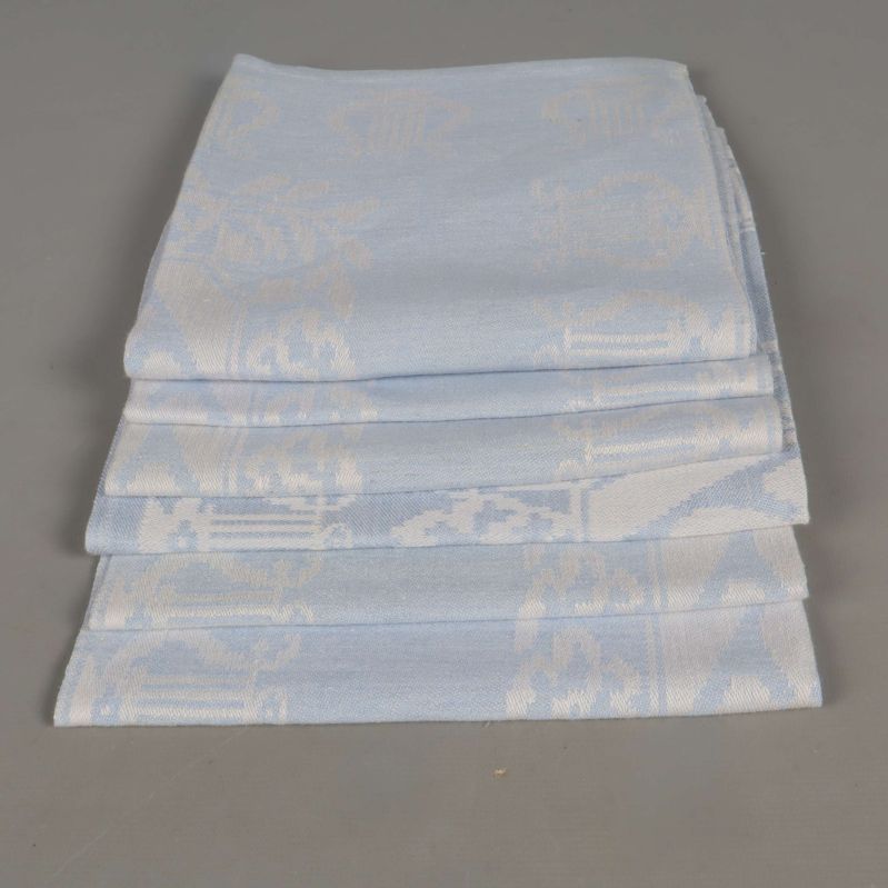 Fyra neatly vikta blåvita linneservetter staplade