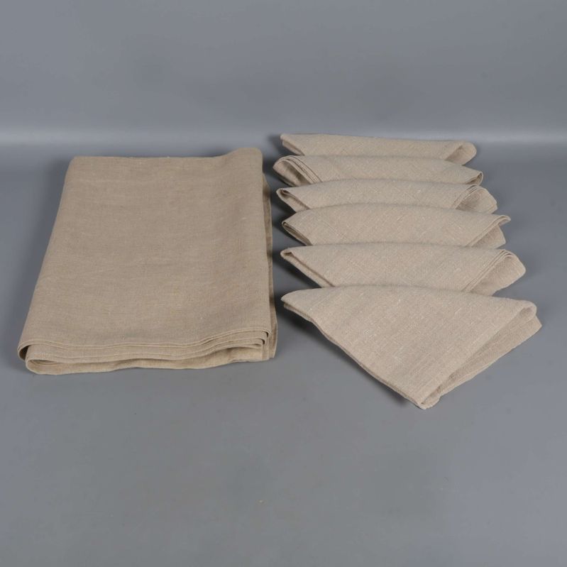 Beige bordsduk och sex vikta servetter bredvid varandra