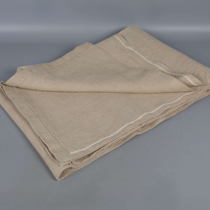 Närbild på ihopvikt beige duk i naturmaterial