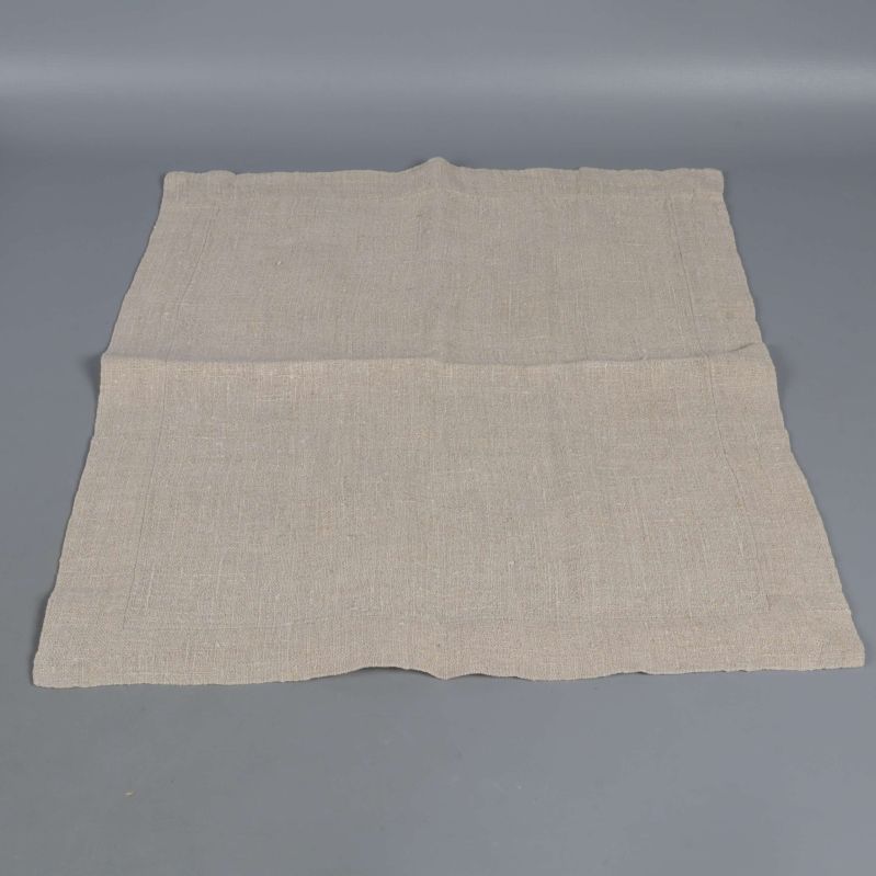 En servett i beige tyg utvikt på golvet