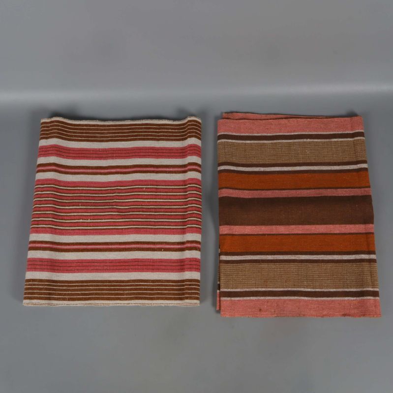 Två vikta randiga dukar med rosa och bruna toner