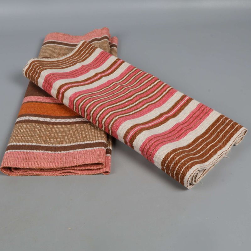 Två ihoprullade randiga dukar på grå bakgrund