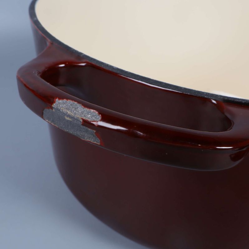 Handtag på gryta med synligt slitage i emaljen