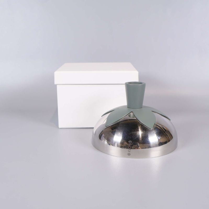 Rund ljusstake framför vit ask från sidan