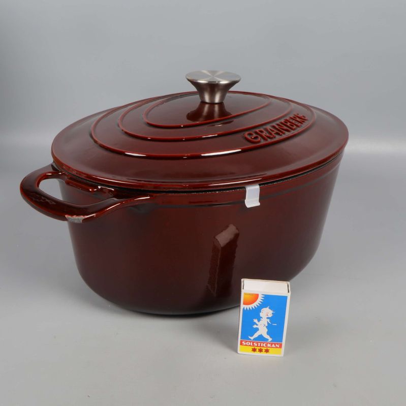 Gjutjärnsgryta med lock och tändsticksask för storleksjämförelse