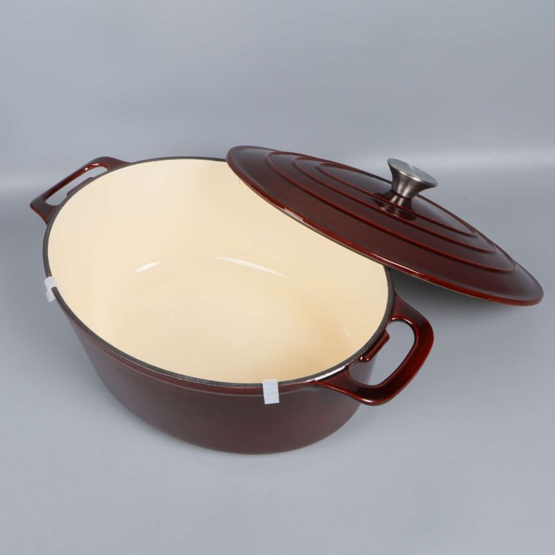 Öppen gjutjärnsgryta med lock och ljus insida