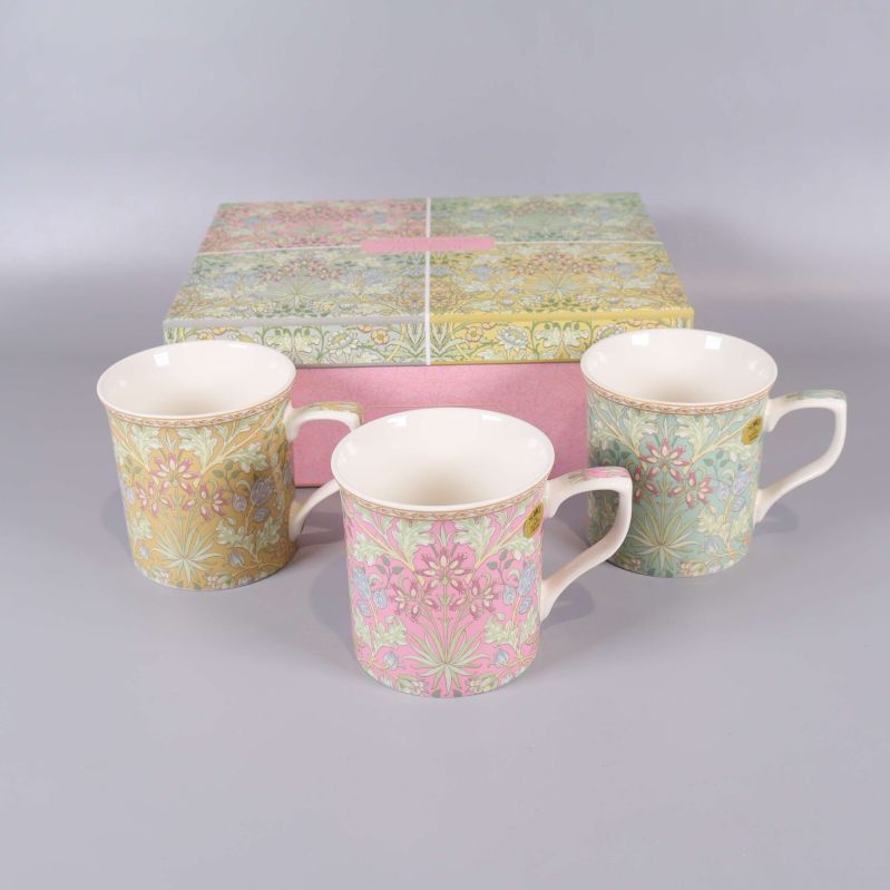 Tre blommiga muggar i pastell med tillhörande ask