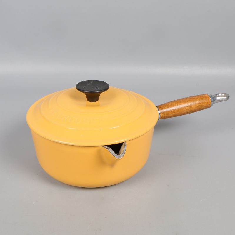 Gul gjutjärnsgryta med trähandtag och lock