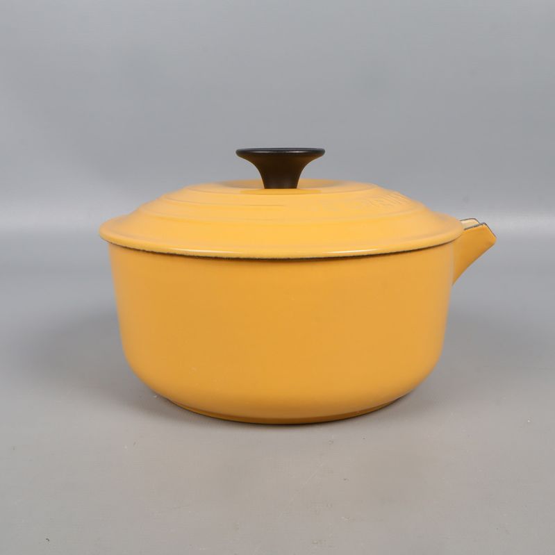 Gul gjutjärnsgryta sedd framifrån med lock