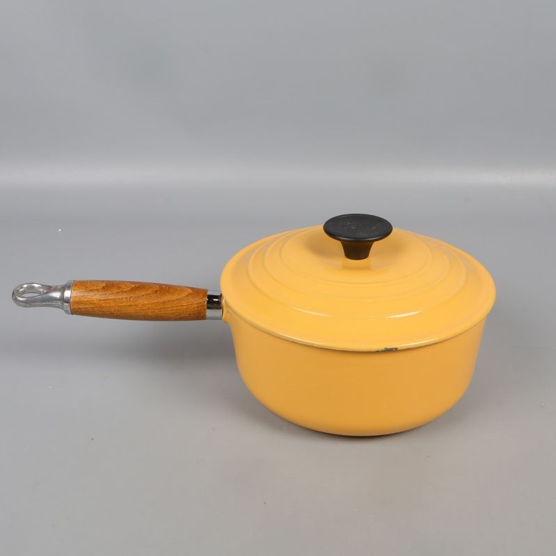 Gul gjutjärnsgryta med handtag fotograferad uppifrån