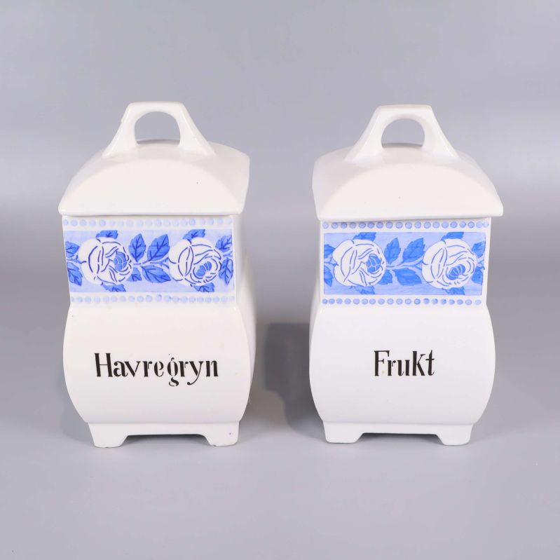 Två vita burkar med blått motiv och svart text